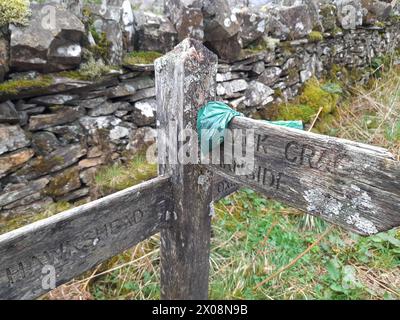 Una borsa per cani posizionata in modo delizioso su un cartello vicino a Tarn Hows nel Lake District Foto Stock