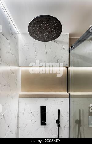 Lussuoso bagno piastrellato in marmo con soffione a pioggia e finiture contemporanee Foto Stock