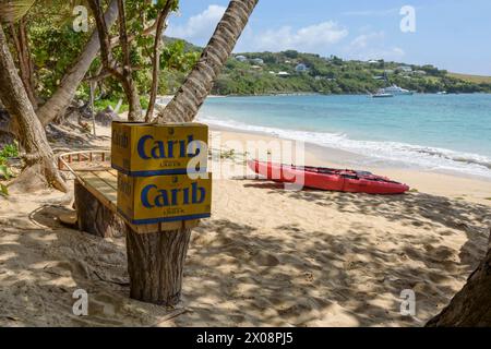 Kayak rosso e birra caraibica sulla spiaggia di Friendship Bay, Bequia Island, St Vincent e Grenadine, Caraibi Foto Stock