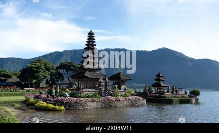 Il tranquillo tempio Ulun Danu Beratan di Bali, con i suoi iconici santuari a gradoni, sullo sfondo delle montagne e circondato da acque riflettenti Foto Stock