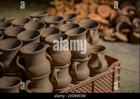 Una serie di vasi di argilla indo marocchina incompiuta è esposta in questa immagine, pronti per la vetratura e la cottura. Ogni pezzo mostra un'intricata maestria artigianale Foto Stock