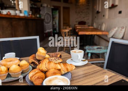 Un intimo ambiente da caffe' caratterizzato da un assortimento di dolci appena sfornati e una tazza di caffe' fumante Foto Stock