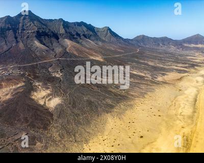 Lo straordinario scatto aereo presenta l'ampio paesaggio desertico e le aspre montagne di Cofete, situato nel sud di Fuerteventura Foto Stock