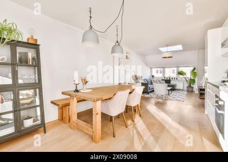 Gli spaziosi interni open space presentano una cucina ben illuminata e una zona pranzo con arredi contemporanei. Foto Stock