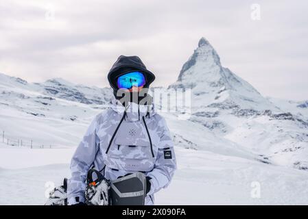 Persona invernale in giacca mimetica con Cervino sullo sfondo, Zermatt, Svizzera. Foto Stock