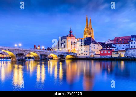 Ratisbona, Baviera, Germania. Cattedrale di St Pietro e il Ponte di pietra sul Danubio di notte. Foto Stock
