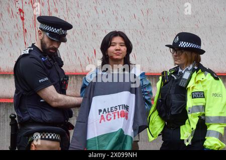 Londra, Regno Unito. 10 aprile 2024. La polizia arresta un manifestante durante la manifestazione. I gruppi di attivisti Palestine Action e Youth Demand hanno spruzzato vernice rossa sull'edificio del Ministero della difesa a Westminster. I gruppi chiedono al governo britannico di smettere di vendere armi a Israele mentre i combattimenti continuano a Gaza. (Foto di Vuk Valcic/SOPA Images/Sipa USA) credito: SIPA USA/Alamy Live News Foto Stock