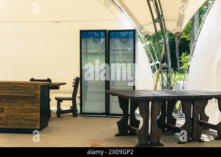 Un padiglione esterno vuoto con tavolo in legno e bibite fresche, perfetto per ospitare riunioni ed eventi in un ambiente panoramico all'aperto Foto Stock