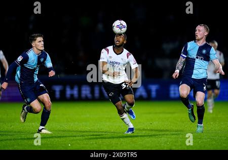 Ebou Adams (centro) della contea di Derby combatte per il ballo con Jack Grimmer (destra) dei Wycombe Wanderers e Freddie Potts durante il match Sky Bet League One ad Adams Park, Wycombe. Data foto: Mercoledì 10 aprile 2024. Foto Stock