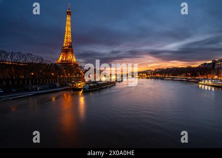 Torre Eiffel al tramonto, con il paesaggio urbano parigino sullo sfondo e il fiume Sena. Foto Stock