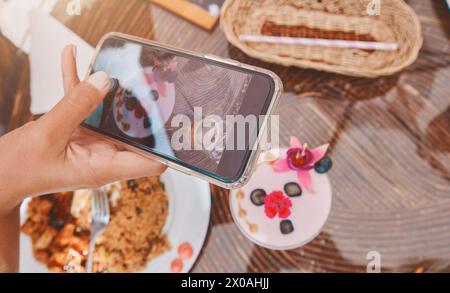 Una persona sta scattando una foto di un dessert al telefono Foto Stock