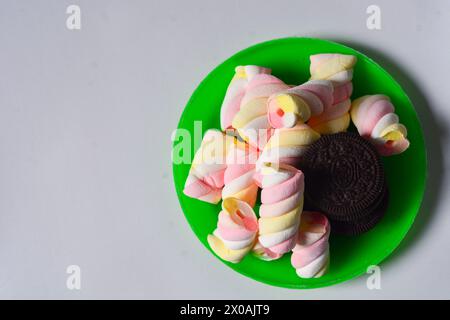 11 maggio 2023, Wonosobo Indonesia: Foto di oreos e marshmallow su un piccolo piatto verde su sfondo bianco. Foto Stock