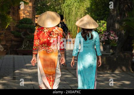 Donne vietnamite in abito tradizionale ao dai nel villaggio, zona rurale Nha Trang Vietnam. La donna vietnamita indossa il tradizionale cappello conico, noto come A. Foto Stock