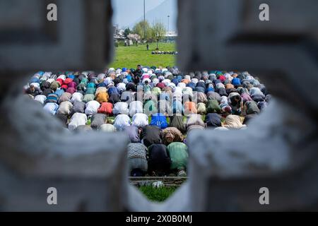 Srinagar, India. 10 aprile 2024. I musulmani del Kashmir stanno offrendo preghiere Eid-al-Fitr fuori da una moschea a Srinagar. Il festival EID-al-Fitr segna la fine del santo mese di digiuno del Ramadan. Nel frattempo, le autorità indiane hanno impedito alle persone di offrire preghiere Eid-al-Fitr nella storica grande Moschea del Kashmir, o Jamia Masjid, per il quinto anno consecutivo nel centro di Srinagar. Credito: SOPA Images Limited/Alamy Live News Foto Stock