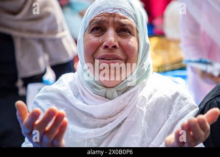 Srinagar, India. 10 aprile 2024. Una donna kashmiri vista offrire preghiere Eid-al-Fitr fuori da una moschea a Srinagar. Il festival EID-al-Fitr segna la fine del santo mese di digiuno del Ramadan. Nel frattempo, le autorità indiane hanno impedito alle persone di offrire preghiere Eid-al-Fitr nella storica grande Moschea del Kashmir, o Jamia Masjid, per il quinto anno consecutivo nel centro di Srinagar. Credito: SOPA Images Limited/Alamy Live News Foto Stock