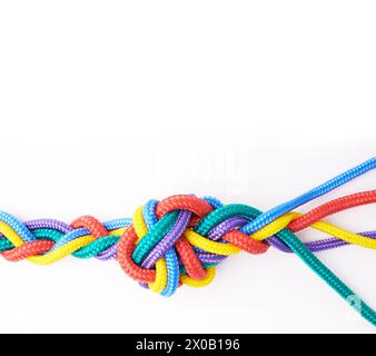 Corda, cravatte e unità di colore in nodo o treccia su sfondo bianco in studio per la solidarietà. Sicurezza, cordone e connessione astratta della società arcobaleno Foto Stock