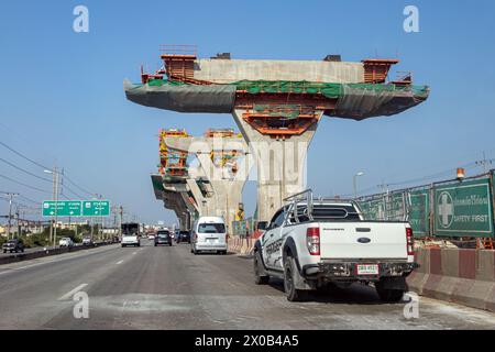 SAMUT SAKHON, TAILANDIA, 24 marzo 2024, automobilisti che guidano la strada Rama II tra Bangkok e Samut Sakhon con la parte sopraelevata parzialmente costruita Foto Stock