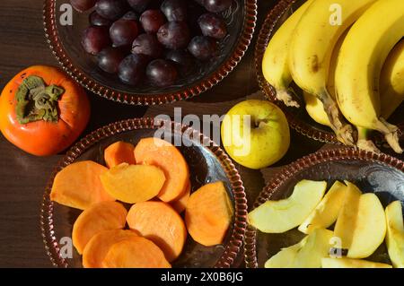 Varietà di frutta di tutti i giorni come banana mela uva e cachi buona fonte di minerali, vitamine e fibre.cibo sano. Foto Stock