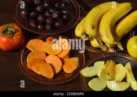 Varietà di frutta di tutti i giorni come banana mela uva e cachi buona fonte di minerali, vitamine e fibre.cibo sano. Foto Stock