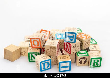 Cubi di legno con alfabeti sparsi isolati su sfondo bianco Foto Stock