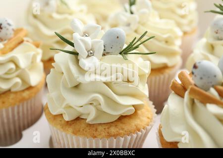 Gustosi cupcake pasquali con panna alla vaniglia in scatola, primo piano Foto Stock