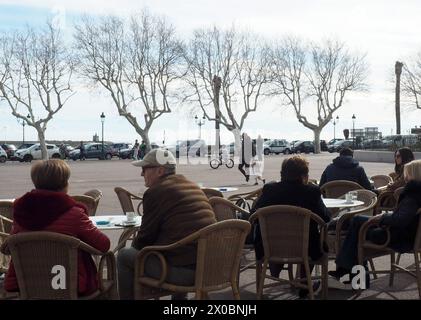 Bastia, Francia. 24 febbraio 2024. Le persone si siedono in una caffetteria sulla famosa Place Saint Nicolas nella città costiera corsa. La Corsica, meta di villeggiatura popolare anche per i tedeschi, è caratterizzata dalla criminalità organizzata e dalle strutture mafiose. Crediti: Rachel Boßmeyer/dpa/Alamy Live News Foto Stock