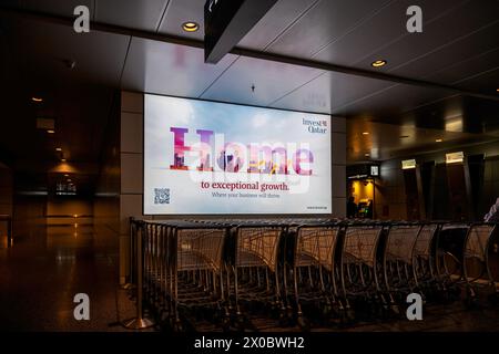 Terminal dell'aeroporto internazionale di Hamad con tutti i cancelli e i viaggiatori che passano. Foto Stock