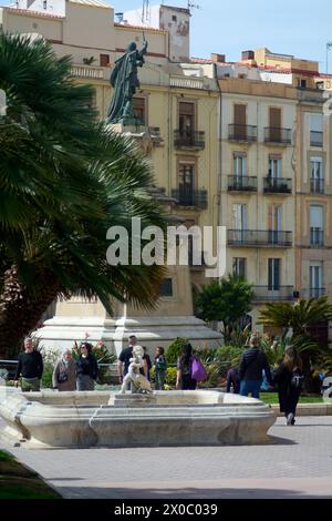 Tarragona, Spagna - 11 aprile 2024: Con una statua in primo piano e l'architettura classica di Tarragona sullo sfondo. Foto Stock