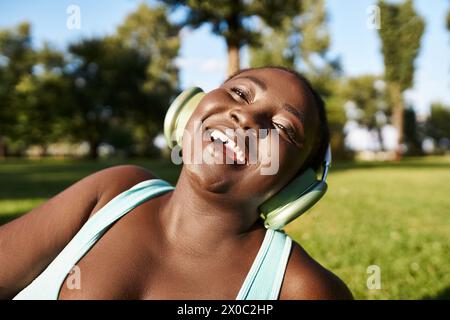 Una donna afroamericana in abbigliamento sportivo e cuffie che ama la natura. Foto Stock