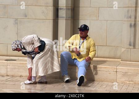 Gran Moschea del Sultano Qaboos turisti nel cortile (Sahn) che tolgono le scarpe prima di entrare nella Moschea di Mascate Oman Foto Stock