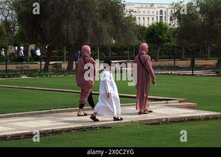 Visitatori della grande Moschea del Sultano Qaboos nei giardini di Mascate Oman Foto Stock