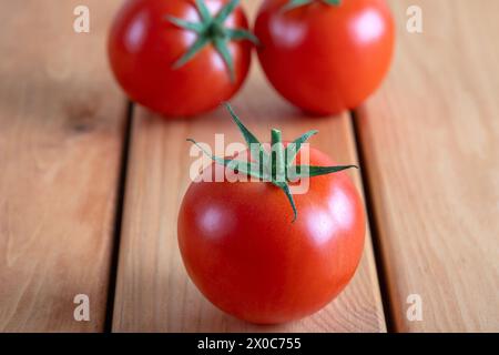 Un gruppo di pomodori rossi su un tavolo di legno Foto Stock