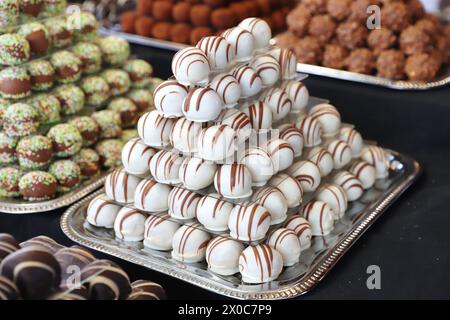 Le caramelle di marzapane al cioccolato hanno riempito vari gusti. Le palle di dolcezza si costruiscono come una piramide per les in una pasticceria Foto Stock