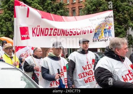 Amburgo, Germania. 11 aprile 2024. Durante uno sciopero di avvertimento a Postbank, i partecipanti a una marcia dimostrativa attraverso il centro di Amburgo. Portano uno striscione con lo slogan "protezione licenziamento!”. Lo sciopero fa parte di un'ondata nazionale di scioperi da parte del sindacato Verdi per aumentare la pressione sul datore di lavoro nei negoziati salariali in corso dopo che il terzo ciclo di negoziati si è concluso senza un accordo. Credito: Bodo Marks/dpa/Alamy Live News Foto Stock