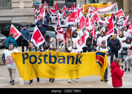 Amburgo, Germania. 11 aprile 2024. I partecipanti a una marcia dimostrativa attraverso il centro di Amburgo durante uno sciopero di avvertimento a Postbank. Lo sciopero fa parte di un'ondata nazionale di scioperi da parte del sindacato Verdi per aumentare la pressione sul datore di lavoro nei negoziati salariali in corso dopo che il terzo ciclo di negoziati si è concluso senza un accordo. Credito: Bodo Marks/dpa/Alamy Live News Foto Stock