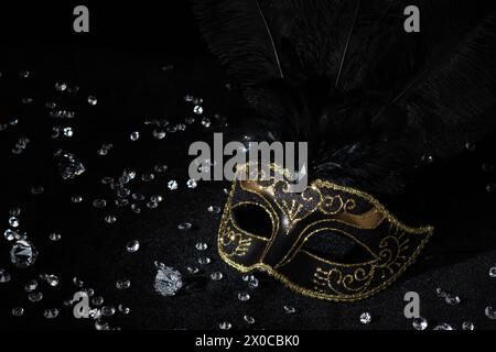 Maschera in oro con pietre preziose su sfondo nero. Foto Stock