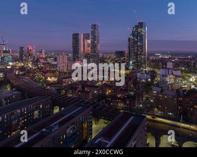 Fotografia aerea/drone con vista su Castlefield in primo piano e sul più ampio centro di Manchester al crepuscolo Foto Stock