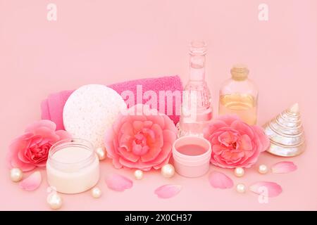 Prodotti per il trattamento di bellezza del centro benessere Rose Flower su rosa. Salute femminile naturale per pelli sensibili, con idratante, olio aromaterapico, scrub. Foto Stock