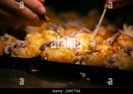 Autentiche palle Takoyaki da Osaka. Il Takoyaki è un alimento giapponese a base di farina di grano e polpo. Foto Stock