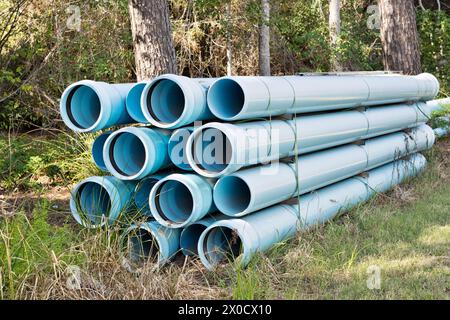 Fascio di tubi per la costruzione di reti idriche sotterranee, apparecchiature industriali in plastica blu pvc fognaria per area boschiva, Houston, Texas USA. Foto Stock
