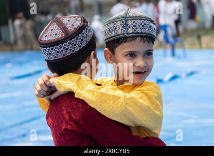 GUWAHATI, INDIA - 11 APRILE: I bambini musulmani si salutano dopo aver eseguito la preghiera di Eid al-Fitr a Eidgah a Guwahati, India, l'11 aprile 2024. I musulmani di tutto il mondo celebrano la festa di Eid al-Fitr, che segna la fine del mese di digiuno del Ramadan Foto Stock