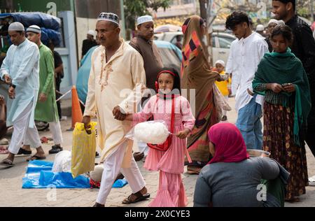 GUWAHATI, INDIA - 11 APRILE: I musulmani con bambini camminano verso un Eidgah per eseguire la preghiera di Eid al-Fitr a Guwahati, India, l'11 aprile 2024. I musulmani di tutto il mondo celebrano la festa di Eid al-Fitr, che segna la fine del mese di digiuno del Ramadan Foto Stock