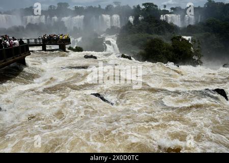 I visitatori si affacciano sulle potenti cascate di Iguazu al loro apice di potenza. Foto Stock