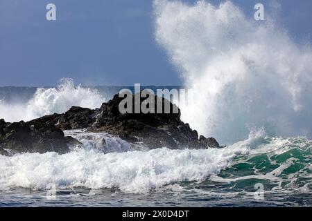 Rocce vulcaniche nere con onde che si infrangono, spiaggia di surf Piedra Playa, El Cotillo, Fuerteventura. Preso nel febbraio 2024 Foto Stock