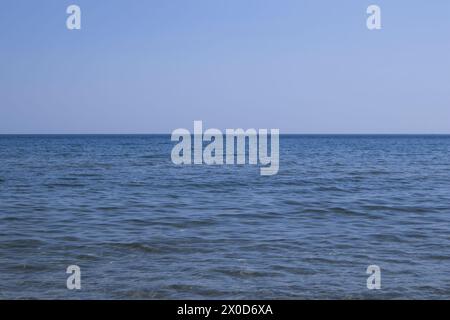 Orizzonte blu dove convergono il cielo senza nuvole e il mare blu. Foto Stock