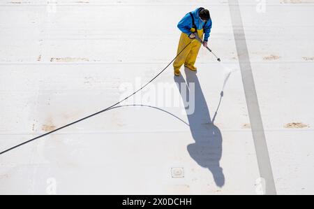 PRODUZIONE - 11 aprile 2024, Sassonia-Anhalt, Halle (Saale): Vicent Förster, apprendista presso le piscine di Halle, pulisce la piscina di nuoto e immersioni nel Nordbad di Halle/Saale con un Kärcher. I preparativi per la nuova stagione sono iniziati da tempo in molte piscine all'aperto. Una volta pulita la piscina, l'acqua verrà versata la prossima settimana. Il riempimento dovrebbe richiedere una settimana. Una volta che la piscina sarà piena, la tecnologia dell'acqua sarà messa in funzione. Poco prima dell'apertura della piscina, saranno prelevati campioni d'acqua per garantire che sia sicuro nuotare e tuffarsi. Le piattaforme per le immersioni, lo scivolo d'acqua Foto Stock