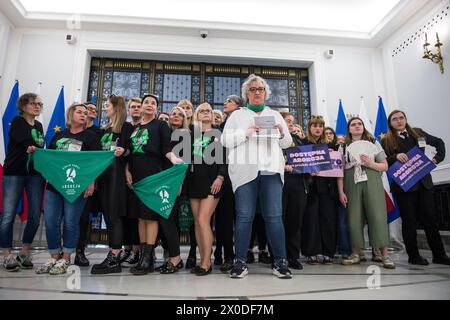 Marta Lempart con gli attivisti dell'organizzazione Women's Strike (Strajk Kobiet) posano nella sala parlamentare. Il parlamento polacco tiene un dibattito da tempo atteso sulla liberalizzazione della rigorosa legge sull'aborto del paese. La nazione tradizionalmente cattolica ha una delle leggi più restrittive in Europa, ma la realtà è che molte donne terminano le gravidanze a casa con pillole spedite dall'estero. I legislatori della camera bassa (Sejm) del parlamento esamineranno quattro diverse proposte l'11 e il 12 aprile durante la 9a sessione del Parlamento. Attualmente l'aborto è regolato da una legge del 1993, che era Foto Stock