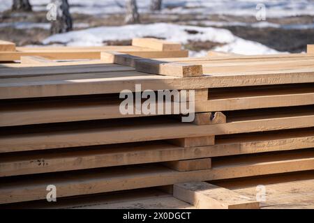 Tavole di legno su un cantiere nella foresta primaverile, primo piano Foto Stock