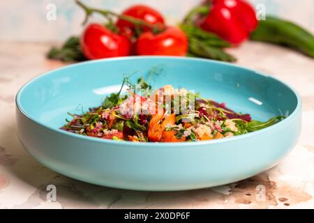 Insalata con zucca, lattuga, pomodori e quinoa. Cospargere con salsa di barbabietole e decorare con le erbe. Isolato su sfondo bianco. Foto Stock