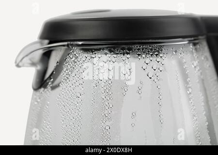 Teiera elettrica in vetro con gocce d'acqua. Isolato su sfondo bianco. Primo piano. Foto Stock